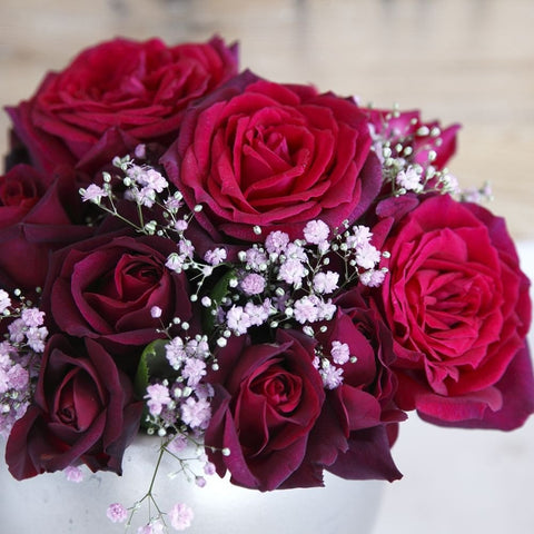 Rose bouquet with dark magenta roses and small purple baby's-breath flowers