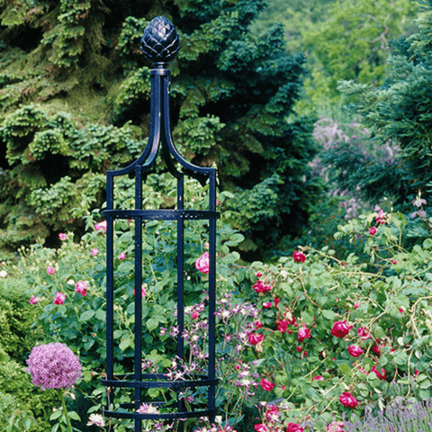 Black metal garden obelisk trellis with rounded top finial and rectangular lattice panels