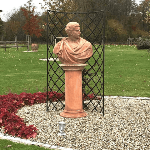 Garden bust sculpture on tall pedestal with decorative metal trellis screen